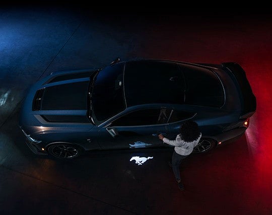 2024 Ford Mustang® Dark Horse™ model with a driver approaching the vehicle | Dick's Canby Ford in Canby OR
